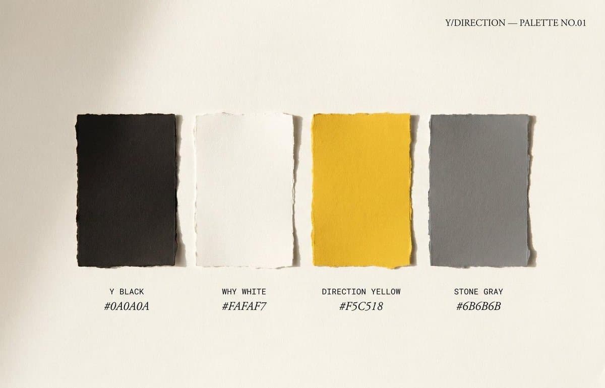 Torn paper colour swatches — charcoal, yellow, gray — pinned on cream.